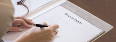 Hand unterschreibt ein Dokument mit der Aufschrift Vorsorgevollmacht.
