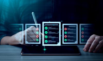 Person nutzt Tablet mit digitalem Stift und prüft digitale Checklisten mit Häkchen und Kreuzen.