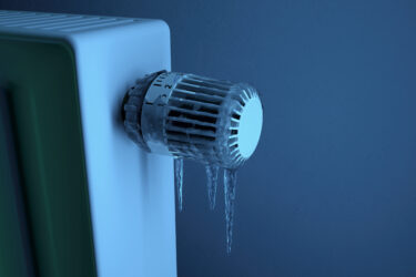 Eine Heizung mit vereistem Thermostat und herabhängenden Eiszapfen.