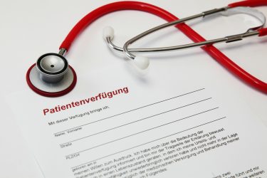 Rotes Stethoskop auf einem Formular für eine Patientenverfügung.